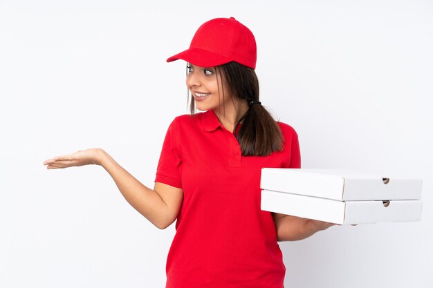 Giovane donna di consegna della pizza sopra il copyspace bianco isolato della tenuta della parete con due mani