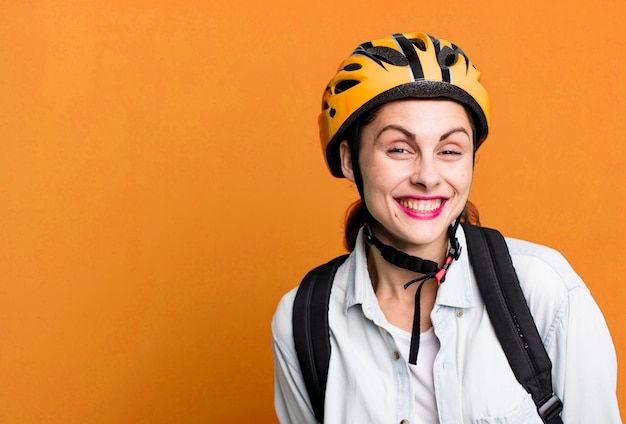 Giovane donna di consegna graziosa dell'adulto con il casco e la borsa della bici