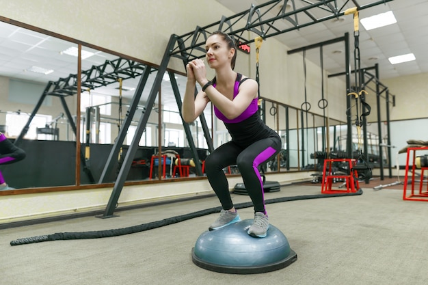 Giovane donna di forma fisica che si esercita nella palestra moderna di sport