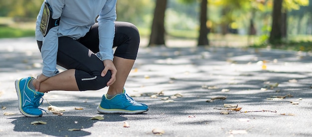 Giovane donna di forma fisica che tiene la sua ferita della gamba di sport, muscolo doloroso durante l&#39;addestramento