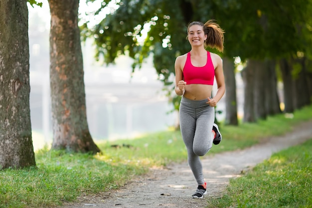 Giovane donna di forma fisica che va in giro nel parco.