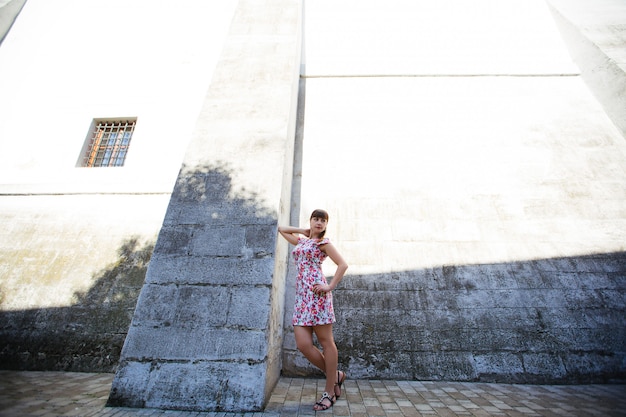 Giovane donna di modello adorabile che esamina macchina fotografica che posa nella città.