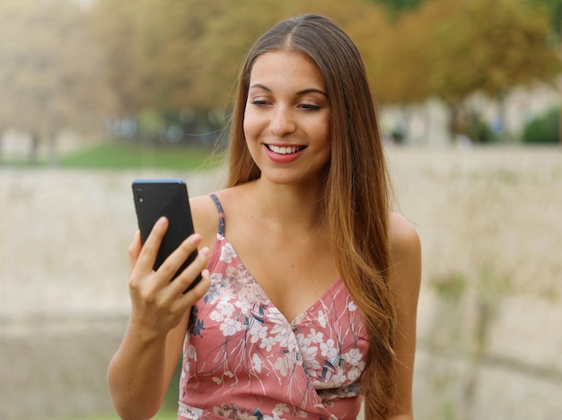 Giovane donna di modo che fa videochiamata all'aperto.