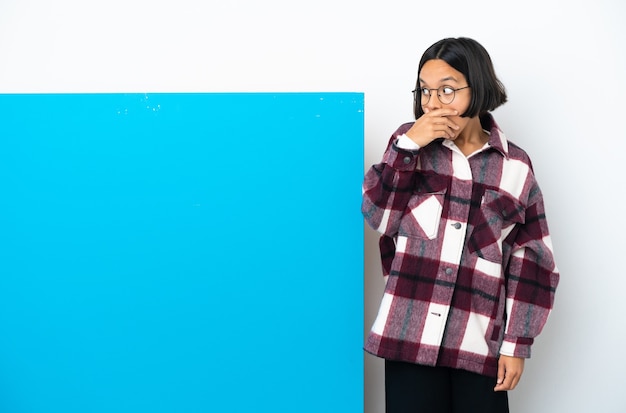 Giovane donna di razza mista con un grande cartello blu isolato su sfondo bianco che fa un gesto a sorpresa mentre guarda di lato