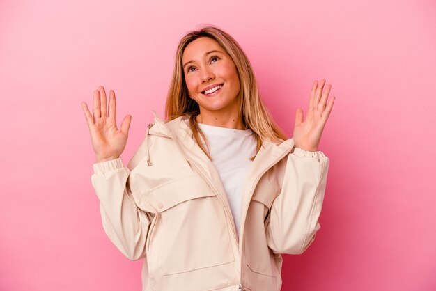 Giovane donna di razza mista isolata su rosa gioiosa che ride molto