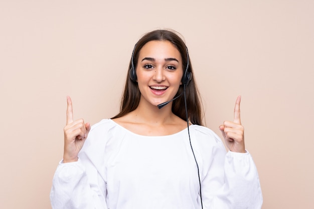 Giovane donna di telemarketer sopra isolata indicando su una grande idea