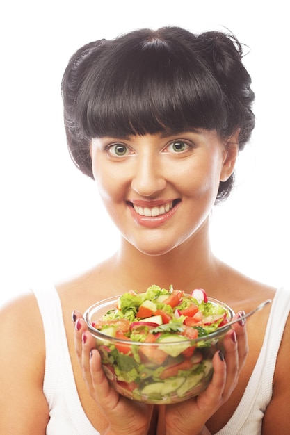 Giovane donna divertente che mangia insalata