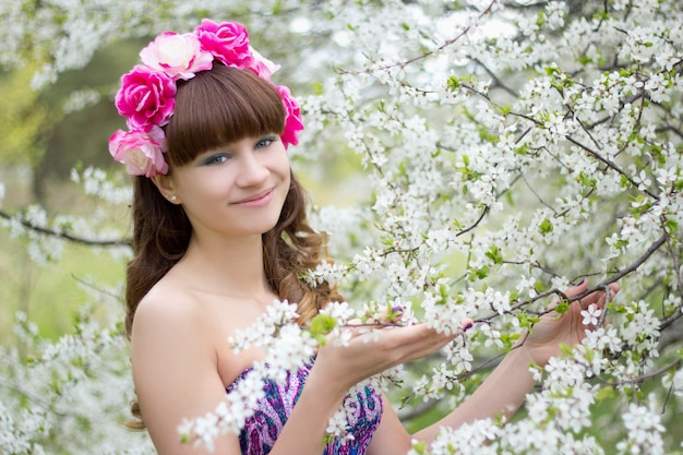 Giovane donna e albero in fiore bianco in giardino