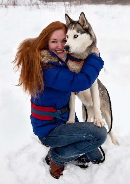 Giovane donna e husky siberiano in inverno