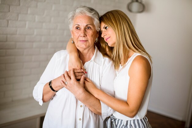 Giovane donna e sua nonna in piedi nella stanza