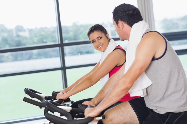 Giovane donna e uomo che lavora a lezione di spinning