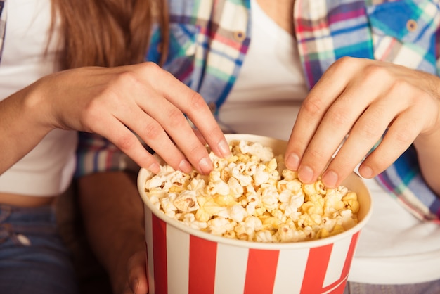 Giovane donna e uomo che mangia popcorn al cinema