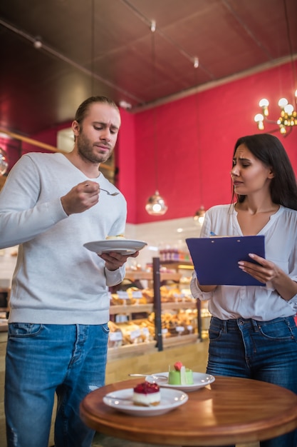 Giovane donna e uomo degustazione di dessert in un ristorante