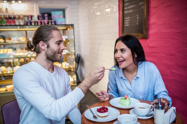 Giovane donna e uomo degustazione di dessert in un ristorante