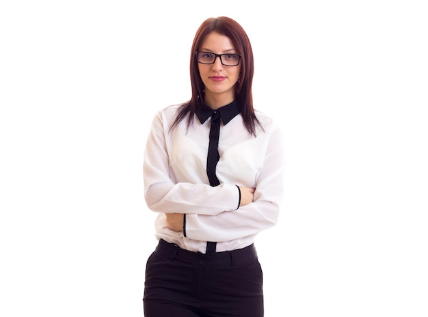 Giovane donna elegante in camicia bianca con lunghi capelli scuri che tiene occhiali neri in studio