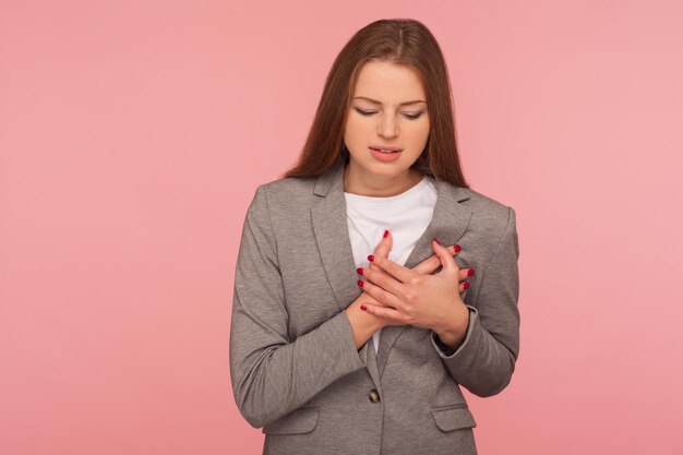 Giovane donna emotiva in giacca su sfondo rosa