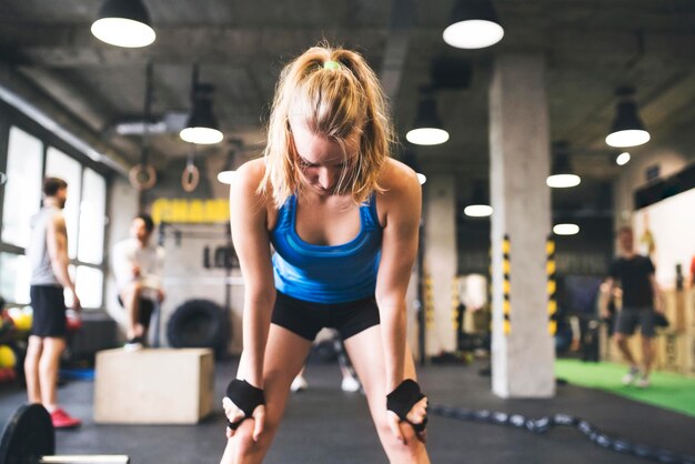 Giovane donna esausta in palestra con una pausa