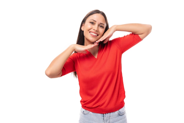 Giovane donna europea sorridente con i capelli dritti scuri vestita con una camicia rossa a maniche corte su un bianco