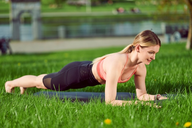 Giovane donna facendo esercizi di yoga nel parco