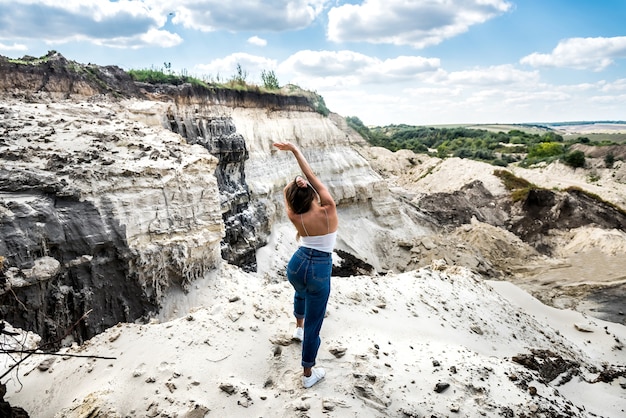 Giovane donna facendo esercizi leggeri in una cava di sabbia. yoga. relax nella natura. giorno soleggiato