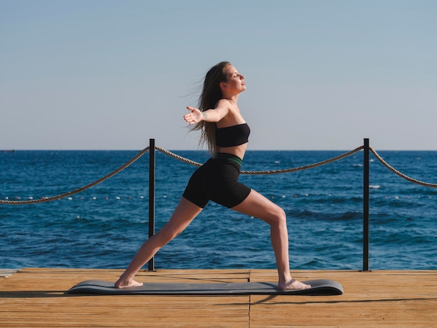 giovane donna facendo yoga sulla spiaggia