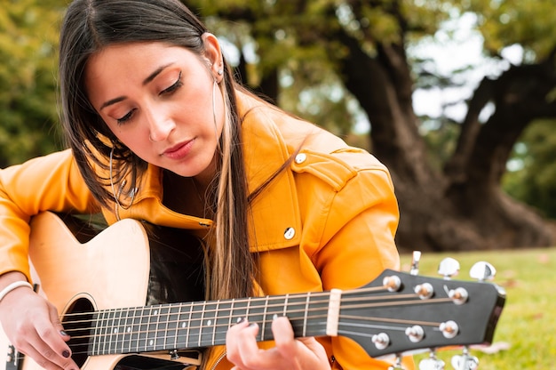 giovane donna felice a un picnic a suonare la chitarra e godersi