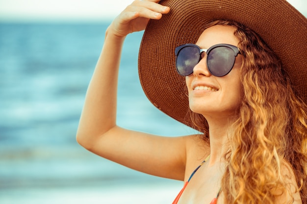 Giovane donna felice alla spiaggia in vacanza di estate.