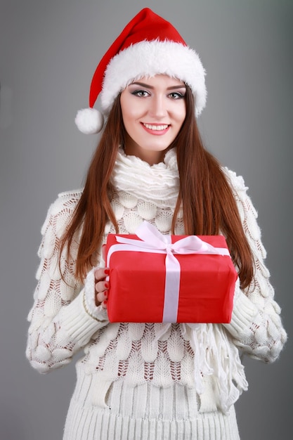 Giovane donna felice che apre una scatola del regalo di Natale