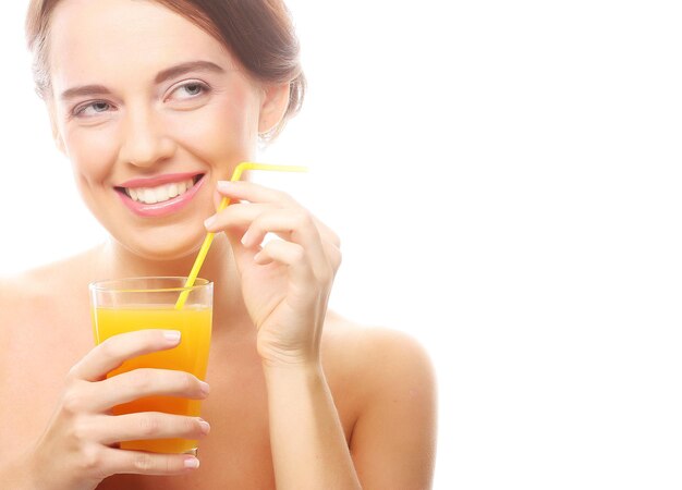 Giovane donna felice che beve il succo di arancia