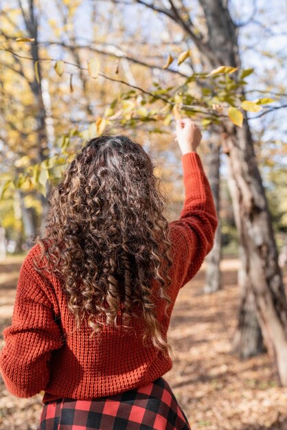 Giovane donna felice che cammina nella foresta di autunno