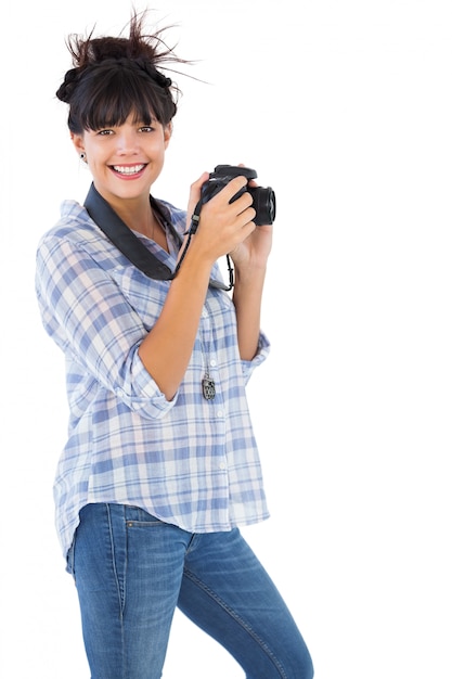 Giovane donna felice che cattura maschera con la sua macchina fotografica