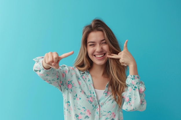 Giovane donna felice che fa la struttura del dito davanti alla parete blu