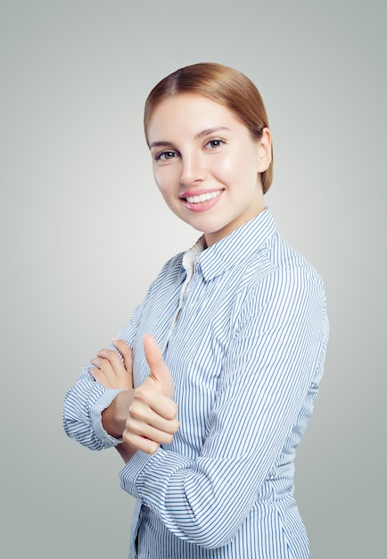 Giovane donna felice che mostra il pollice su uno sfondo bianco emozione espressioni facciali espressive