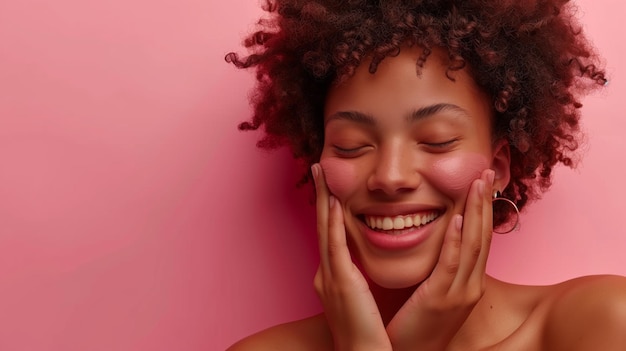 Giovane donna felice con i capelli ricci che sorride con gli occhi chiusi sullo sfondo rosa