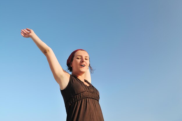 giovane donna felice con le braccia spalancate che rappresenta il concetto di libertà