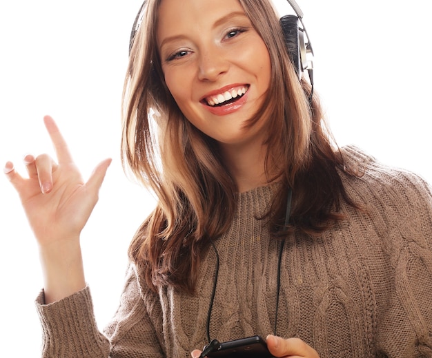 Giovane donna felice con le cuffie che ascolta musica su sfondo bianco