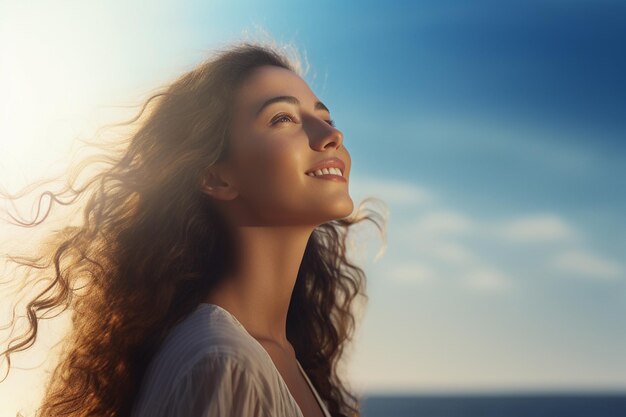 giovane donna felice con lo zaino che guarda al cielo al mare