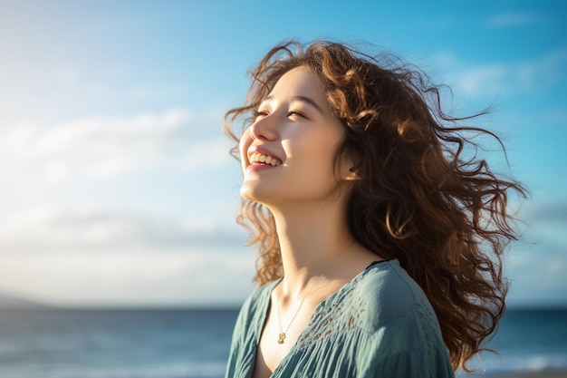 giovane donna felice con lo zaino che guarda al cielo al mare