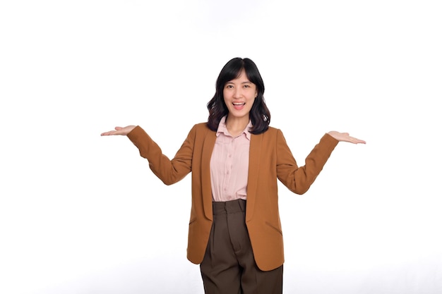 Giovane donna felice di etnia asiatica che indossa le mani allargate guardando la fotocamera isolata su sfondo bianco ritratto in studio Concetto di stile di vita delle persone