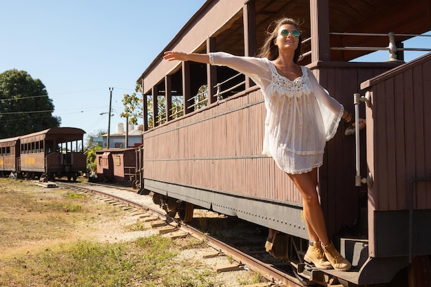 Giovane donna felice sulla vecchia carrozza del treno in legno