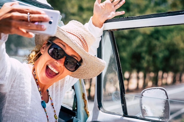 Giovane donna felicissima ed eccitata che scatta foto selfie con smartphone mobile Le persone di sesso femminile usano il cellulare durante il viaggio Strada e all'aperto sullo sfondo Persone che condividono la vita sui social media