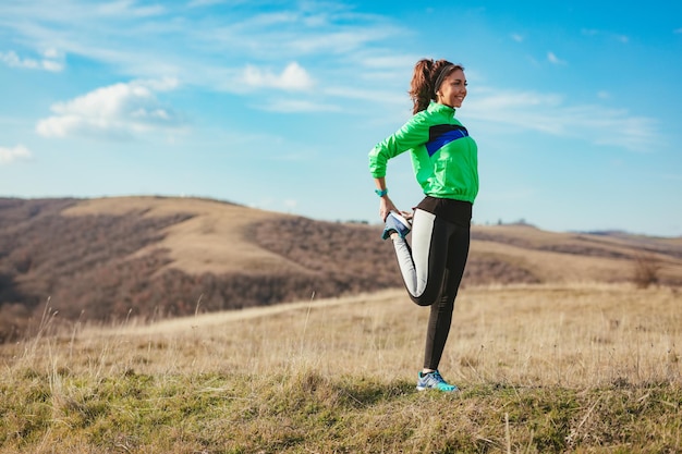 Giovane donna fitness che fa esercizio di stretching dopo aver fatto jogging nella natura.