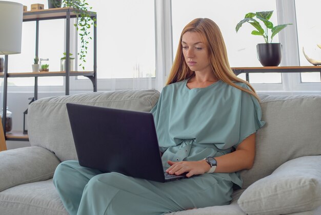 giovane donna freelance lavora a casa per un apprendimento online su laptop