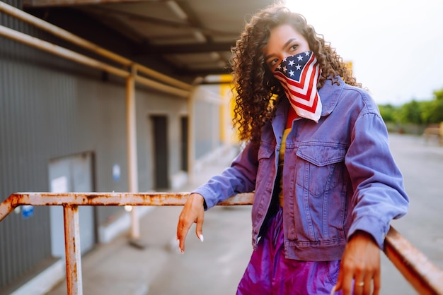 Giovane donna funky con bandana americana che balla da sola in stradaSport danza e cultura urbana