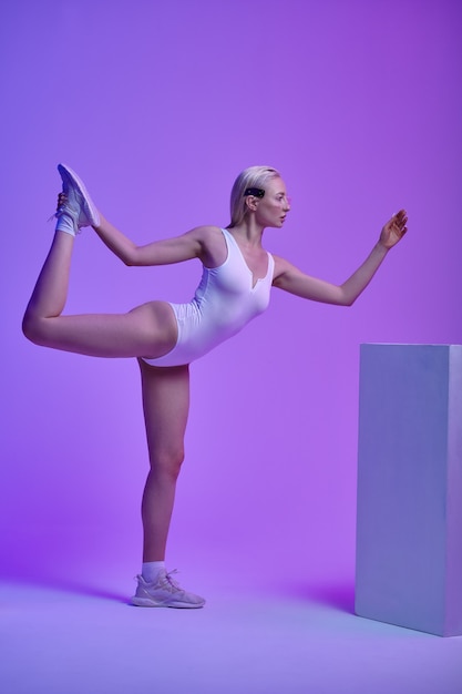 Giovane donna futuristica che fa esercizio di equilibrio