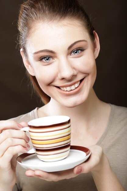 Giovane donna graziosa che beve caffè