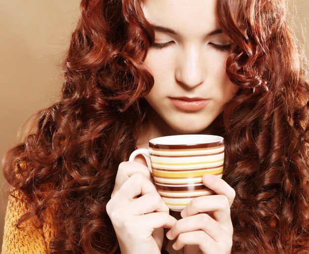 Giovane donna graziosa che beve caffè