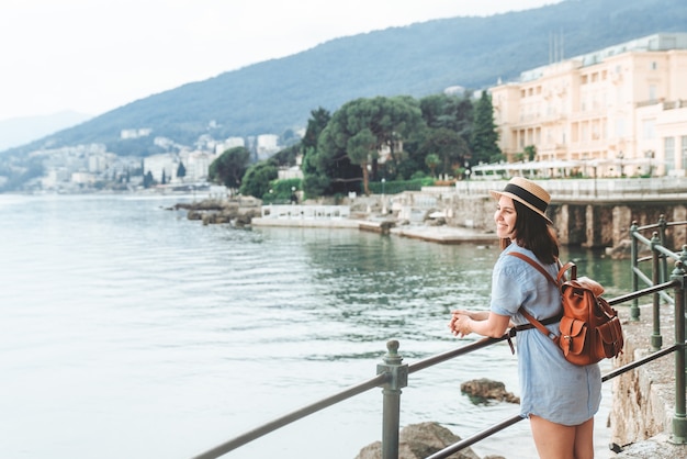 Giovane donna graziosa che cammina dallo spazio della copia di concetto di vacanza estiva della banchina del mare