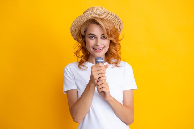 Giovane donna graziosa che canta una canzone con un microfono che presenta un evento o una festa Ragazza felice di canto