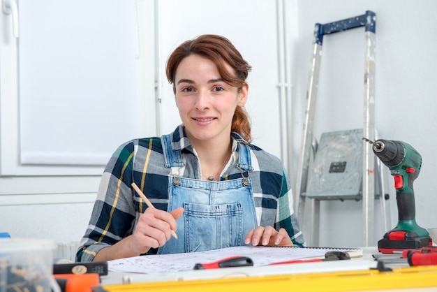 Giovane donna graziosa che fa lavoro di DIY a casa